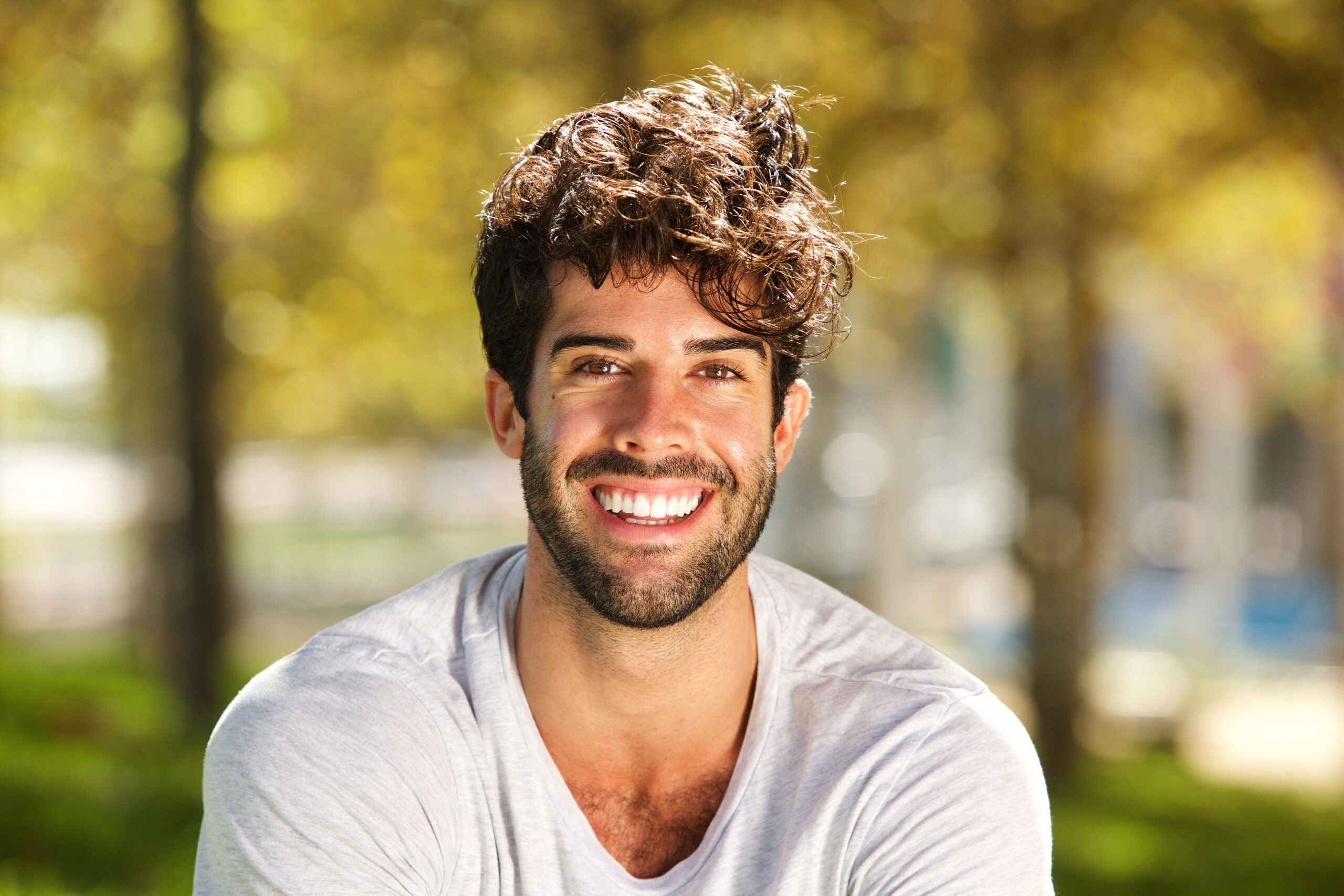 Close up portrait of handsome man with beard smiling outside