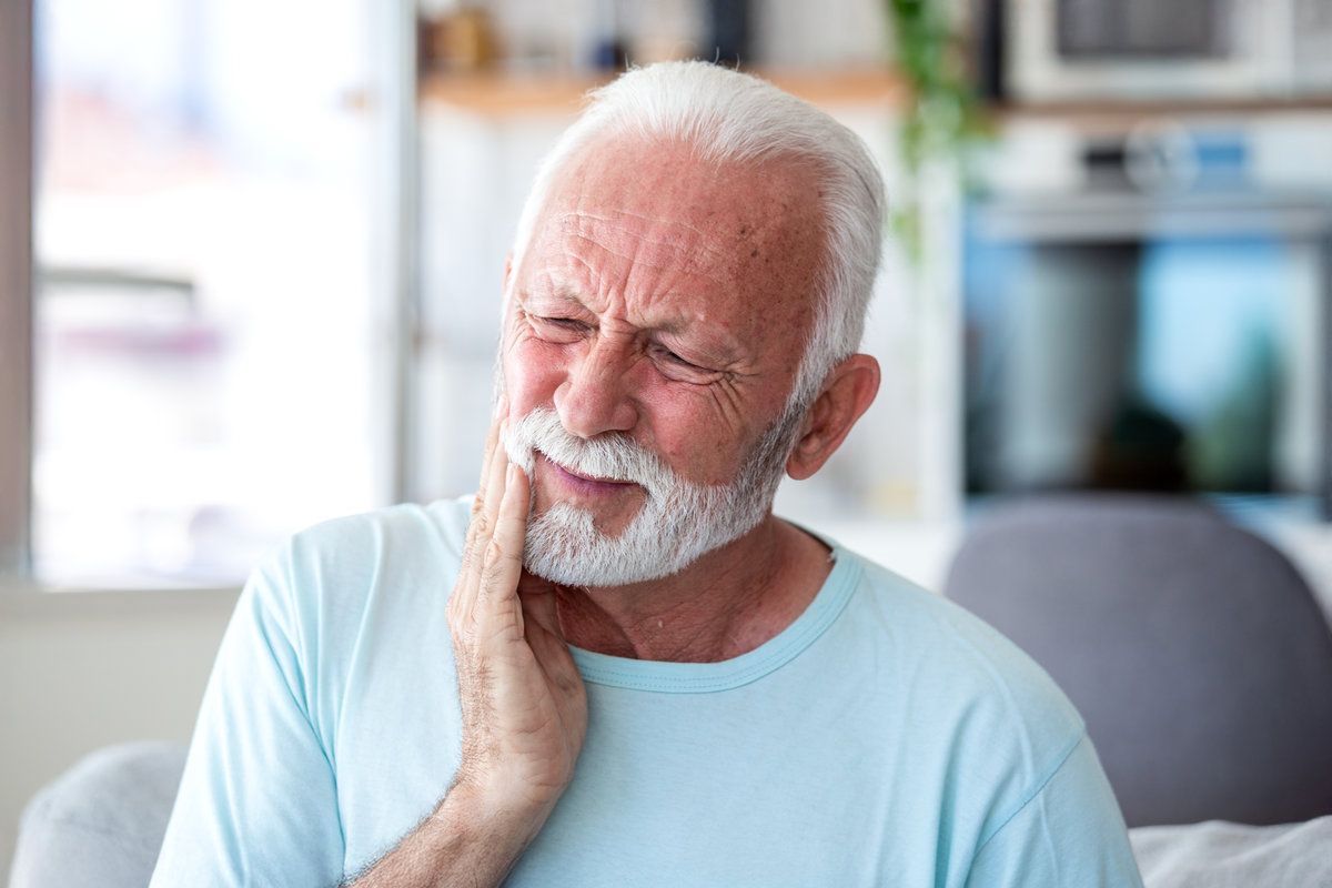 Elderly man experiencing dental pain